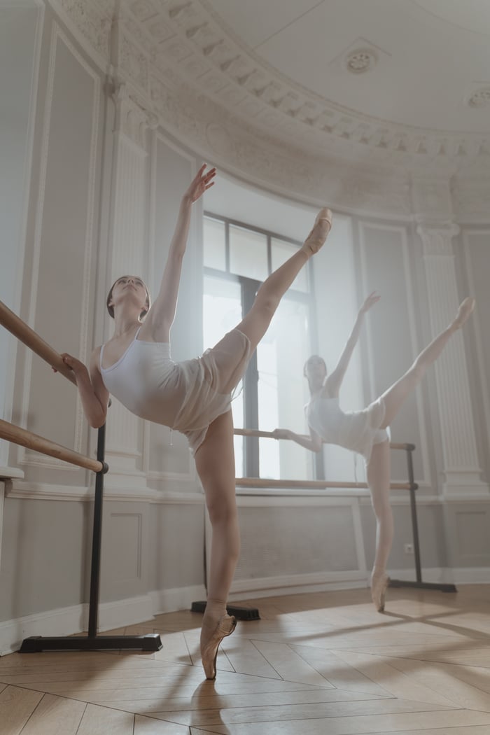 Ballet dancer practicing in a bright studio, showcasing flexibility and grace.