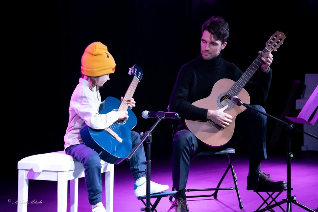 mężczyzna i chłopiec grający na gitarach